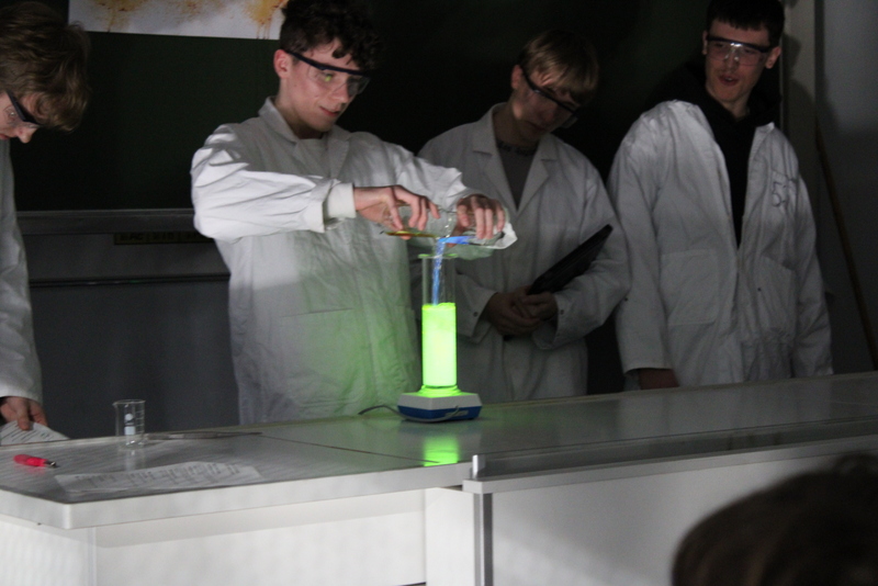 19.Chemie-Versuch Schüler mischt zwei Flüssigkeiten und erzeugen Lichteffekt